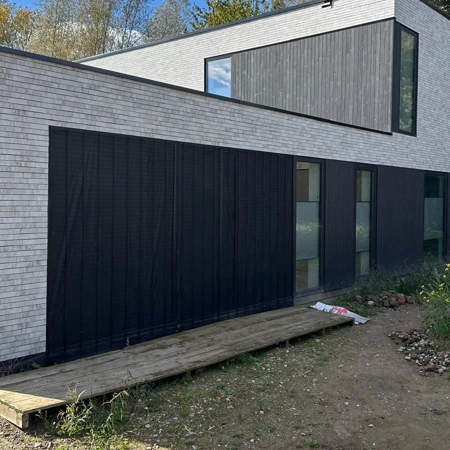 Detail crop showing the vertical thermally treated timber cladding