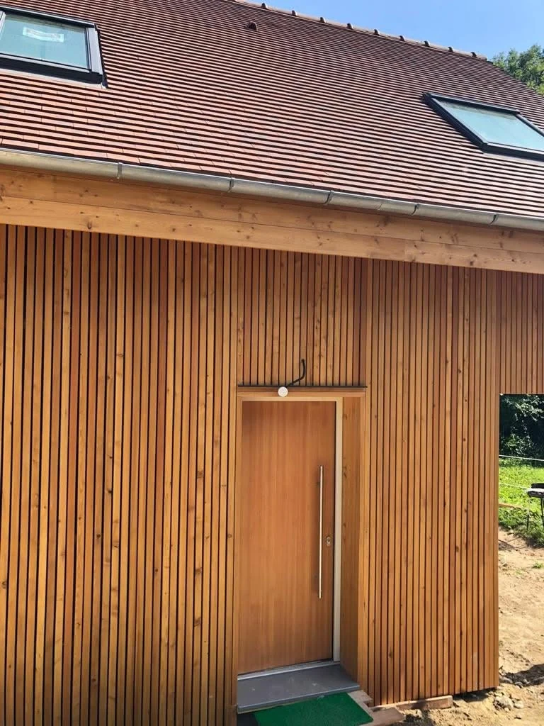 Entrance door detail set within the larch cladding