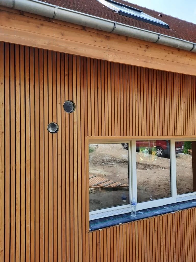Façade band showing guttering, timber beam and slatted cladding