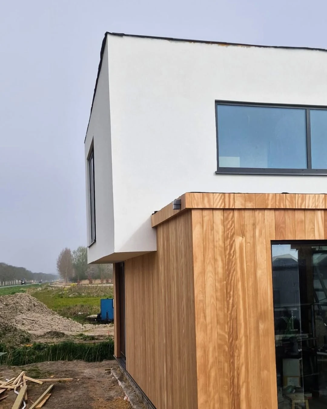 Corner elevation of the Dutch residence showing the junction between the rendered upper floor and vertical timber cladding