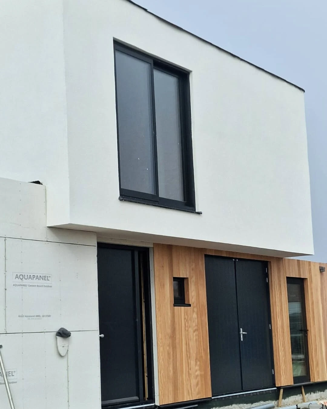 Front façade of the Dutch residence showing timber cladding and recessed entrance
