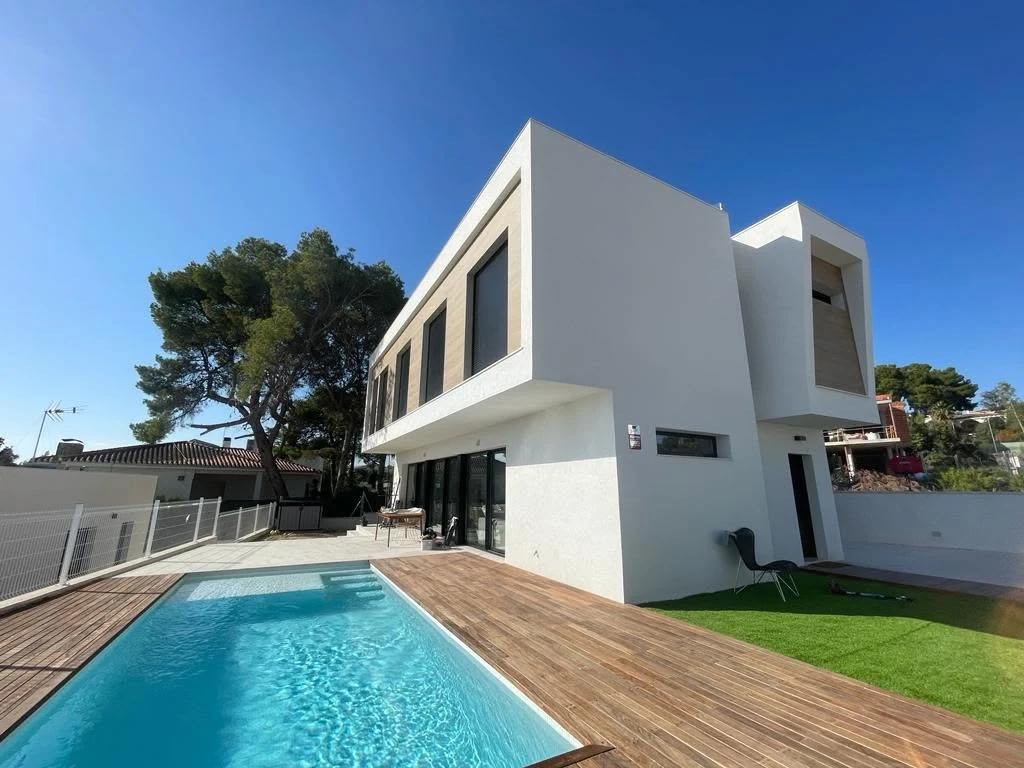 Vivienda Timber Frame terminada con fachada blanca contemporánea y piscina