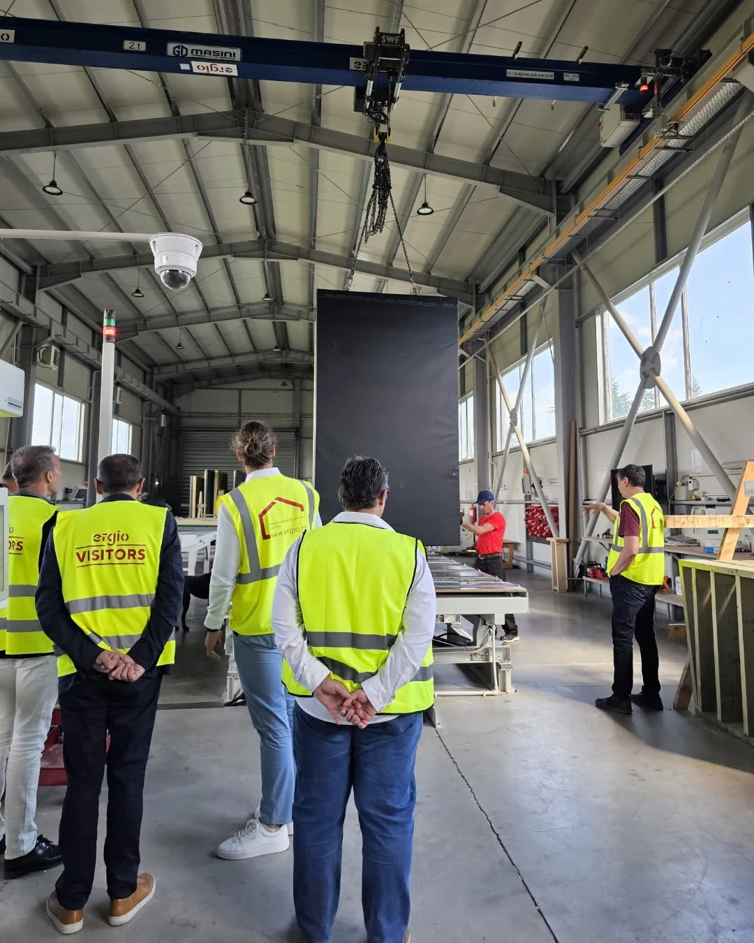 Visitantes observando el flujo de producción de ERGIO durante una visita a la fábrica en Comănești, Rumanía