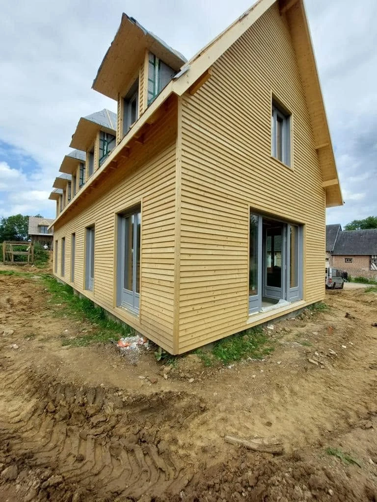 Corner perspective of the timber-frame residence showing cladding and roof geometry