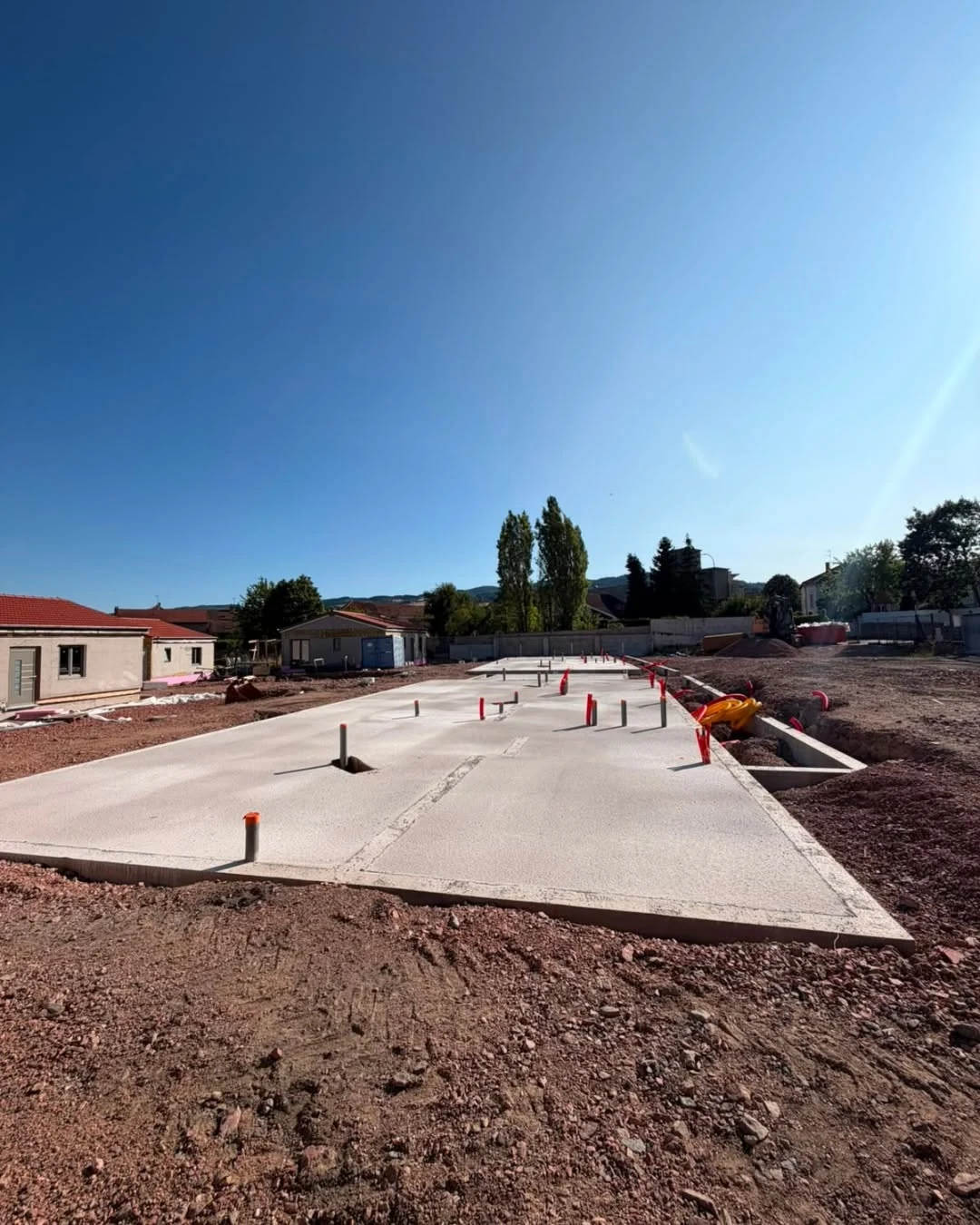 Hospitality site prepared with foundations and protected prefabricated building packages before assembly