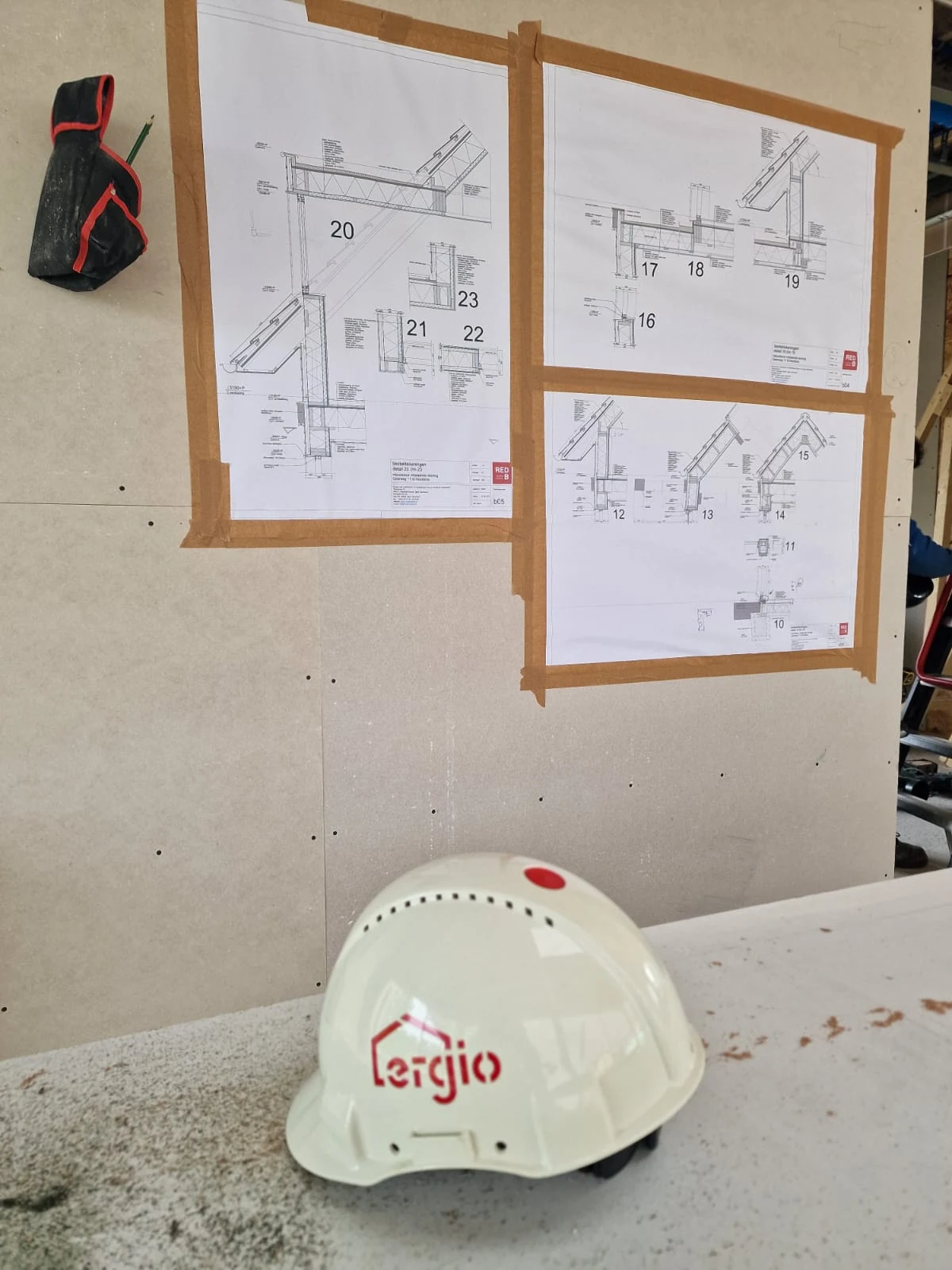 ERGIO safety helmet beside technical assembly drawings on site