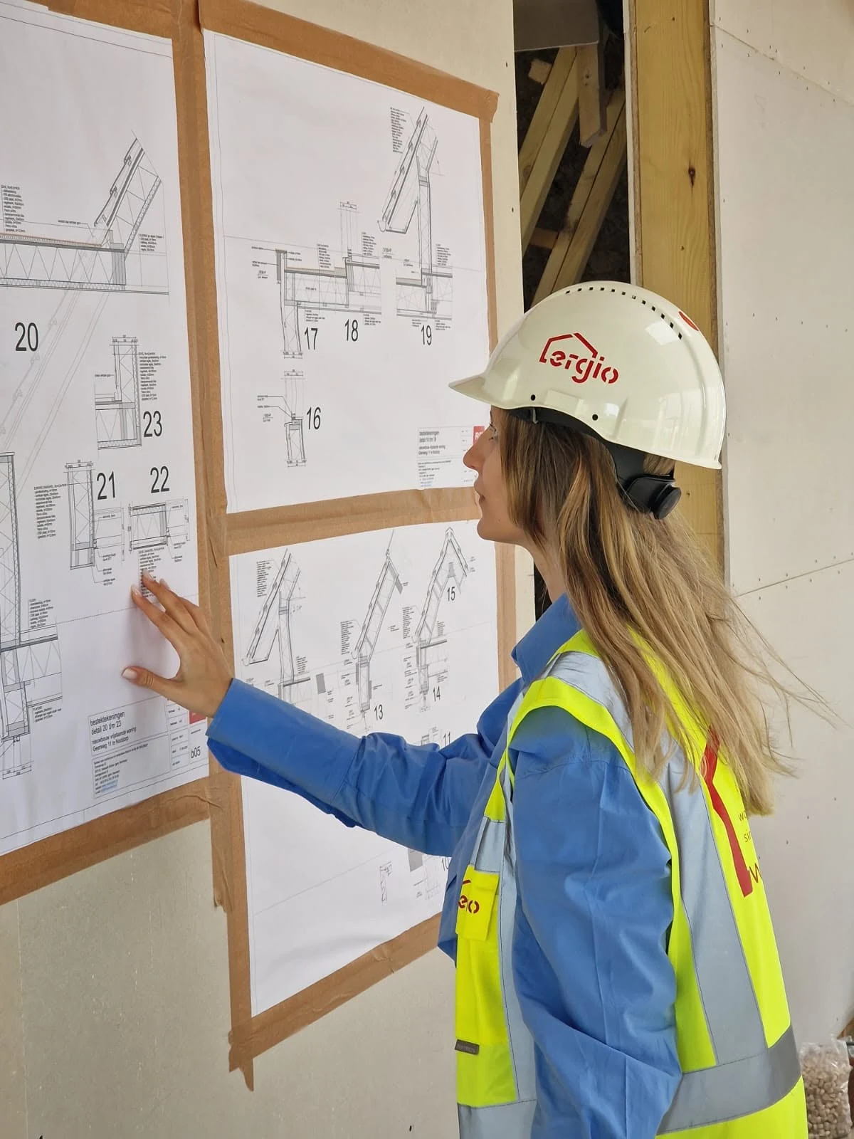 ERGIO site technician reviewing construction details during timber assembly