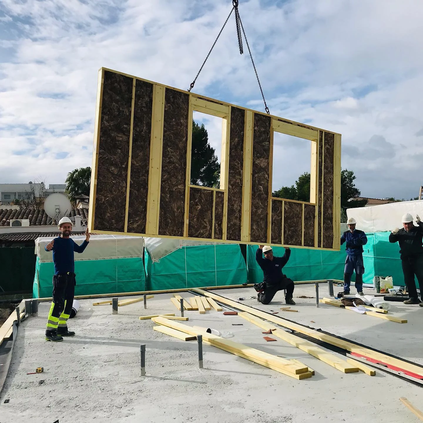Prefabricated timber wall panel being lifted into position by crane