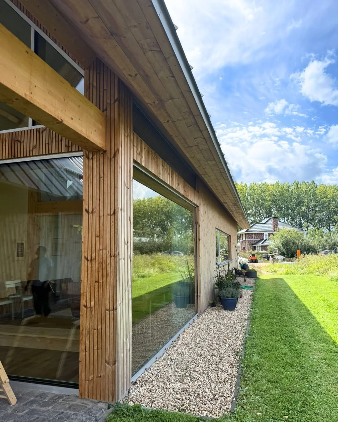 Timber facade and large glazed openings on the completed building