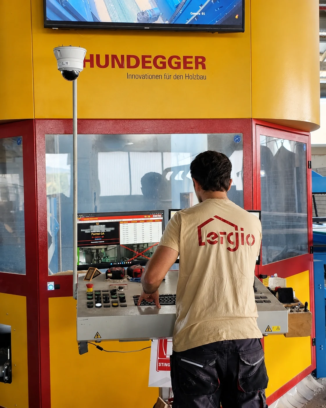 Operario de ERGIO controlando el mecanizado robotizado multieje de madera Hundegger