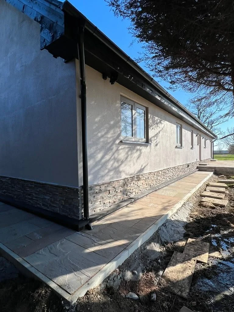 Side elevation showing stone plinth and pathway