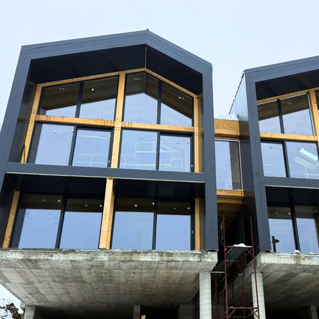 Large glazed openings integrated with the visible timber hotel structure