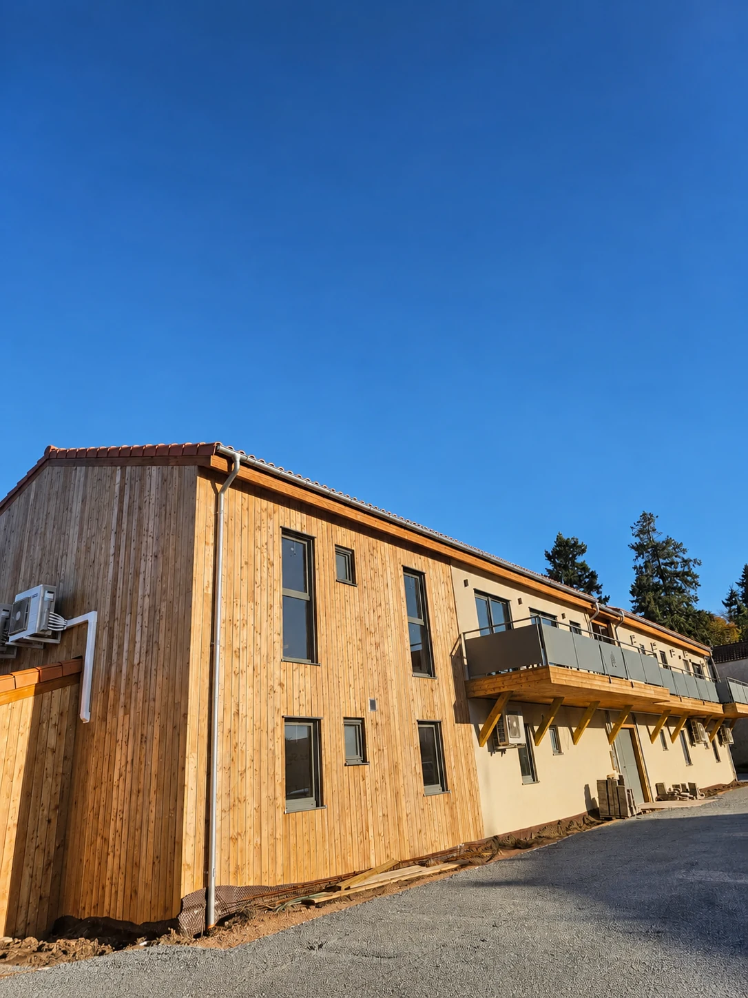 Long timber-clad façade with balconies at Village Seniors