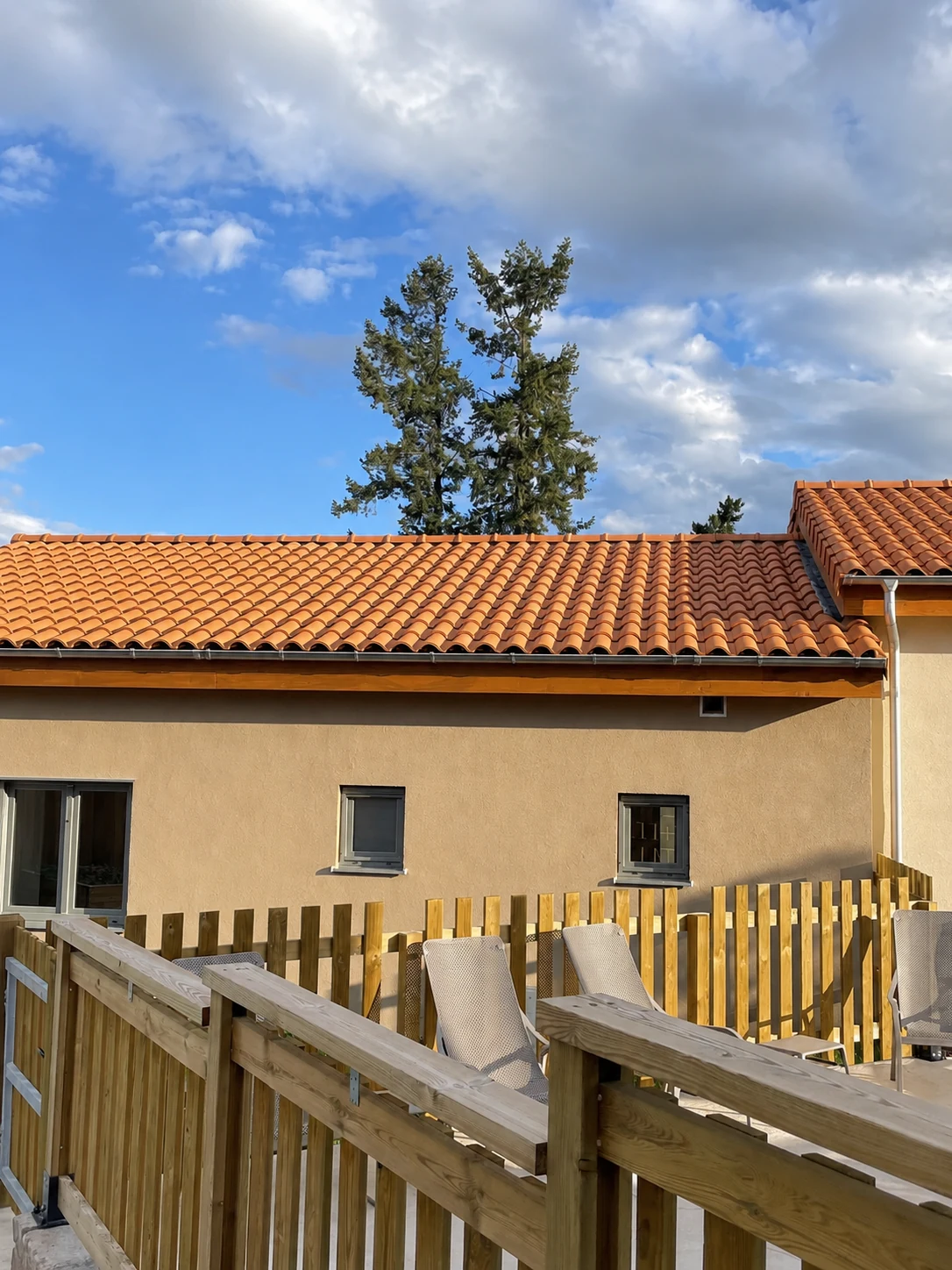 Village Seniors roofline and terrace fencing under a blue sky